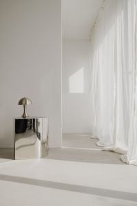 Kaboompics - Sunlit Minimal Room with Chrome Pedestal and Sheer Curtains