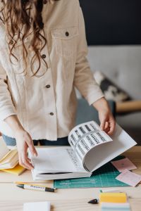 Kaboompics - Woman Holding Open Book Above Notes and Pencils