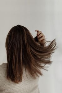 Kaboompics - Woman Tossing Medium-Length Brown Hair in a Beige Knit Sweater