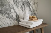 Kaboompics - Wooden Bench with Towels and Soap Against Arabescato Wall