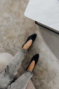 Kaboompics - Pointed-Toe Black Heel on Textured Beige Rug Beside Marble Table, Neutral Fashion Background