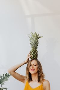 Kaboompics - Woman Balancing a Pineapple on Her Head, White Studio Lifestyle Portrait in Yellow Top