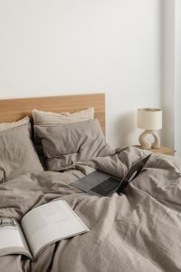Kaboompics - Open Laptop and Book on Gray Bedding