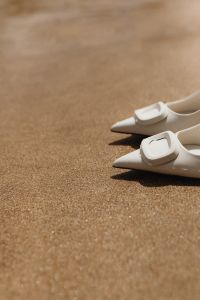 Kaboompics - White Buckle Pumps Close-Up on Sunlit Sand