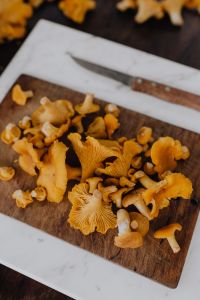 Kaboompics - Close Up Chanterelle Mushrooms And Knife On Cutting Board