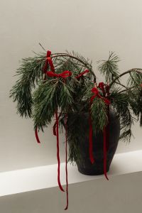 Kaboompics - Close Up Pine Branches with Red Velvet Bows in Black Vase