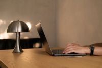 Kaboompics - Man Typing on a Laptop at a Wooden Desk