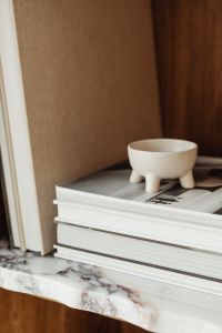Kaboompics - Close-Up of an Open Design Book and Ceramic Bowl in a Walnut Bookcase