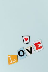 Kaboompics - LOVE Spelled with Colorful Cutout Letters, Vertical Romantic Poster Design with Open Space