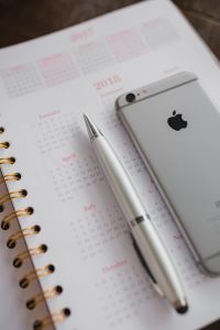 Kaboompics - Pink 2018 Planner with Silver Smartphone and Pen, Vertical Desk Flat Lay