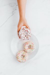 Colorful Iced Donuts with Sprinkles on a Glass Plate