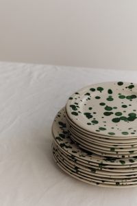 Kaboompics - Green Splatter Plate Stack with Minimal Background Copy Space
