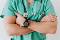 Kaboompics - Close-Up Crossed Arms with Watch and Stethoscope on Mint Scrubs, Healthcare Detail
