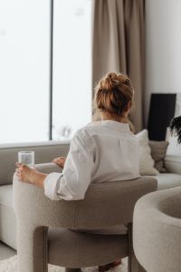 Kaboompics - Woman Sitting in a Neutral Armchair with a Glass