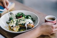 Kaboompics - Close up image of young woman eating classic breakfast at restaurant