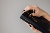 Kaboompics - Hands Holding a Black Holy Bible and Cross Necklace with Copy Space