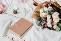 Kaboompics - Fresh Flowers and Pink Notebook on an Unmade Bed