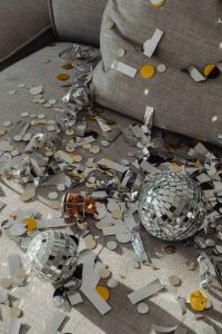 Kaboompics - Disco Balls on Gray Sofa with Champagne Cork and Metallic Streamers