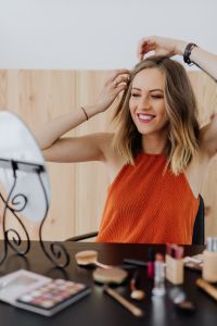 Kaboompics - Smiling Woman Styling Her Hair While Looking into a Vanity Mirror