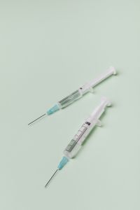 Kaboompics - Two Syringes on a Pale Mint Green Background