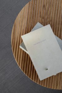 Kaboompics - Books on a Fluted Oak Table with Gray Copy Space