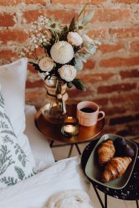 Kaboompics - Pink Coffee Cup, Croissants and White Floral Bouquet on a Brass Bedside Table, Breakfast in Bed