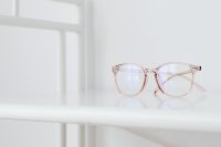 Kaboompics - Rose-Gold Eyeglasses on a White Table by a Bright Window with Wide Copy Space