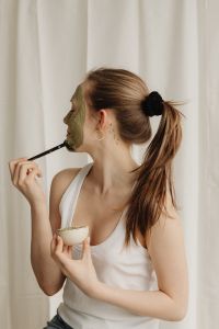 Kaboompics - Side View of Woman Applying Green Face Mask with a Brush