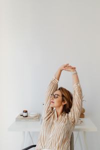 Kaboompics - Woman Stretching at Home Office Desk with Large White Copy Space