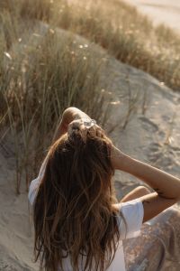 Kaboompics - Faceless Woman in White Shirt Sitting in Coastal Dunes