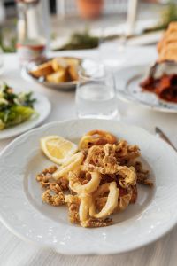 Kaboompics - Fried Seafood Platter with Lemon and Blurred Table Setting