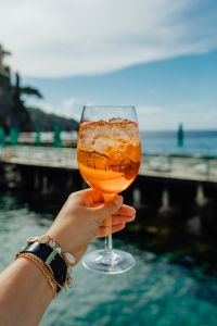 Kaboompics - Aperol Spritz on Seafront Stone Wall with Coast Behind