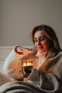 Kaboompics - Woman Warming Her Hands by Candlelight Under a Blanket