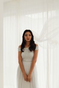 Kaboompics - Bride With a Floating Wedding Veil Against Sheer Window Curtains