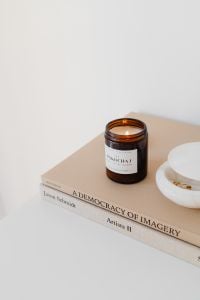 Kaboompics - Amber Candle on Books with White Bowl and Blank Wall