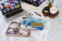 Kaboompics - Laptop, Floral Notebook And Coffee Arranged On A White Bed