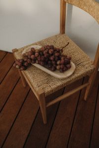 Kaboompics - Red Grapes on Woven Chair in Warm Interior