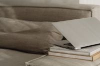 Kaboompics - Open Laptop on Stacked Books Against a Neutral Sofa, Minimal Home Office