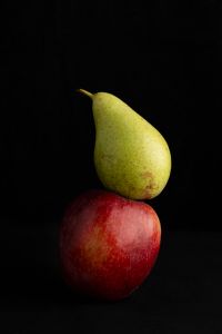 Kaboompics - Green Pear Balanced on Red Apple in Dark Still Life