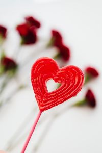 Kaboompics - Heart-Shaped Lollipop With Blurred Red Carnations
