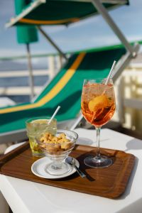 Kaboompics - Aperol Spritz with Straw and Italian Taralli on Beach Chair