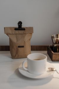 Kaboompics - Coffee Cup and Paper Coffee Bag Beside a Metal Dripper