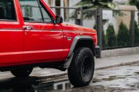 Kaboompics - Red Jeep Cherokee Parked Beside a City Sidewalk After Rain