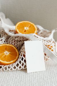Kaboompics - Vertical Orange Slice and Blank Business Card in a Reusable Produce Bag
