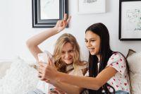Kaboompics - Smiling Teen Friends Posing for a Smartphone Selfie in a Cozy Living Room