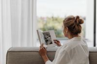 Kaboompics - Woman Reading a Magazine on a Neutral Sofa