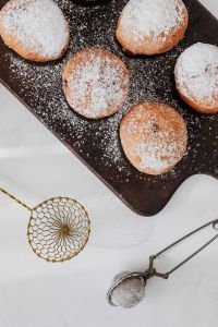 Kaboompics - Powdered Doughnuts and Brass Sifter in a Portrait Flat Lay