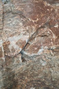Kaboompics - Weathered Coastal Rock with Layered Rust-Brown and Pale Gray Mineral Veins, Natural Stone Texture