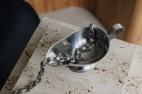 Kaboompics - Metal Bowl with Silver Chain on a Travertine Pedestal