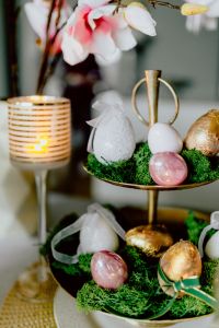 Kaboompics - Lit Candle beside White and Gold Easter Eggs on Moss with Spring Blossoms